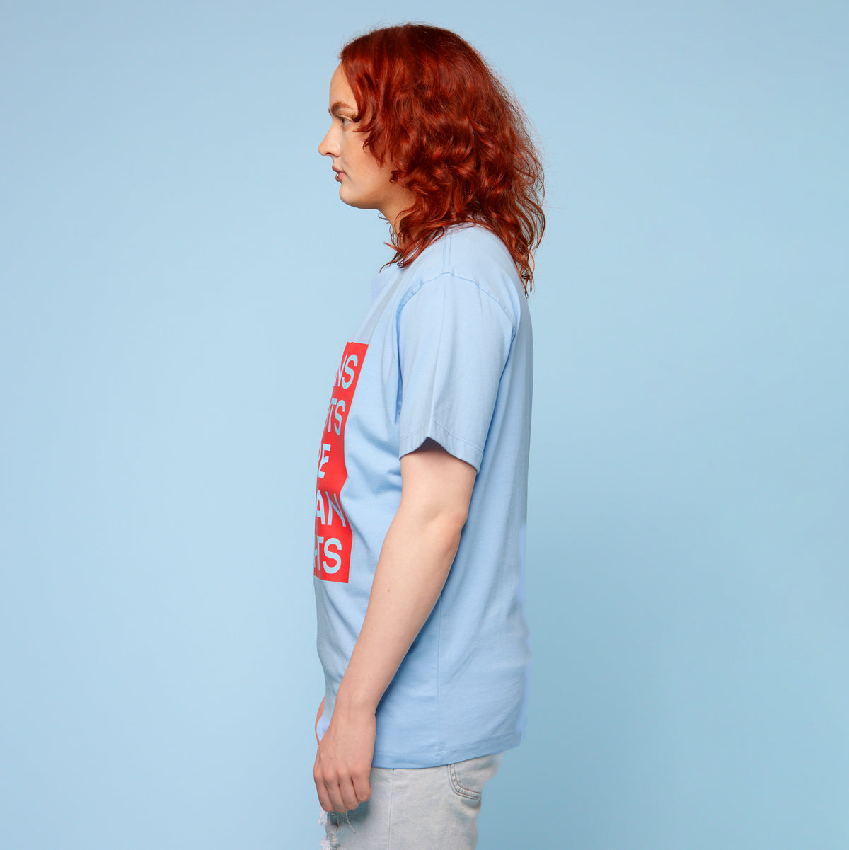 Person wearing a pride t-shirt with the words &#39;trans rights are human rights&#39; - side view