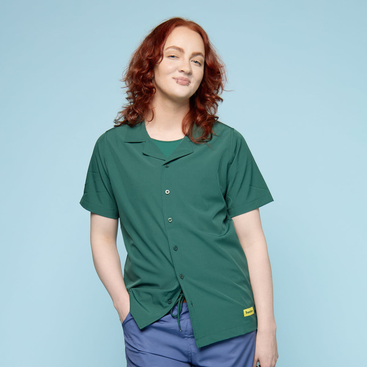 Person wearing a green button up swim shirt with a collar - front view