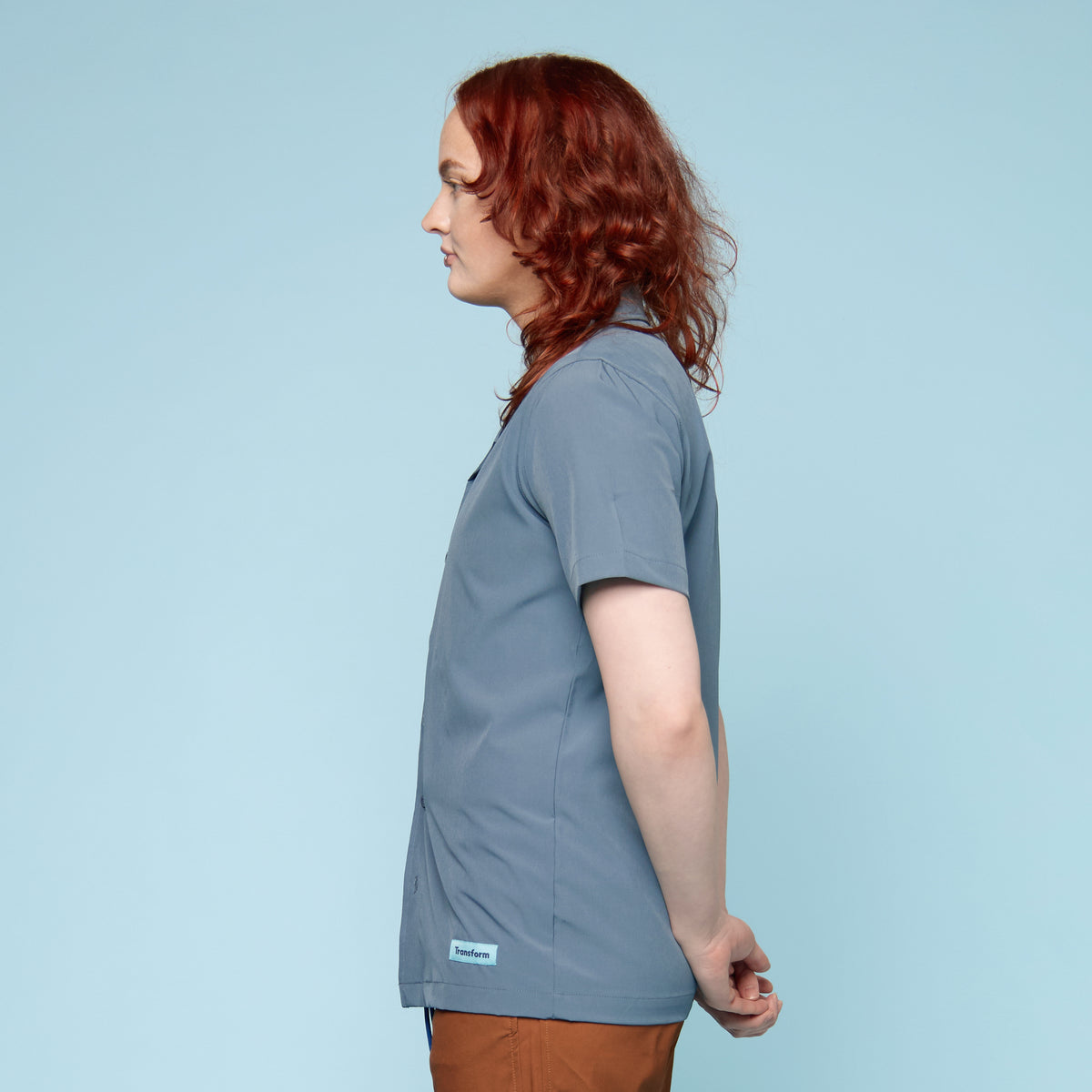 Person wearing a blue button up swim shirt with a collar - side view