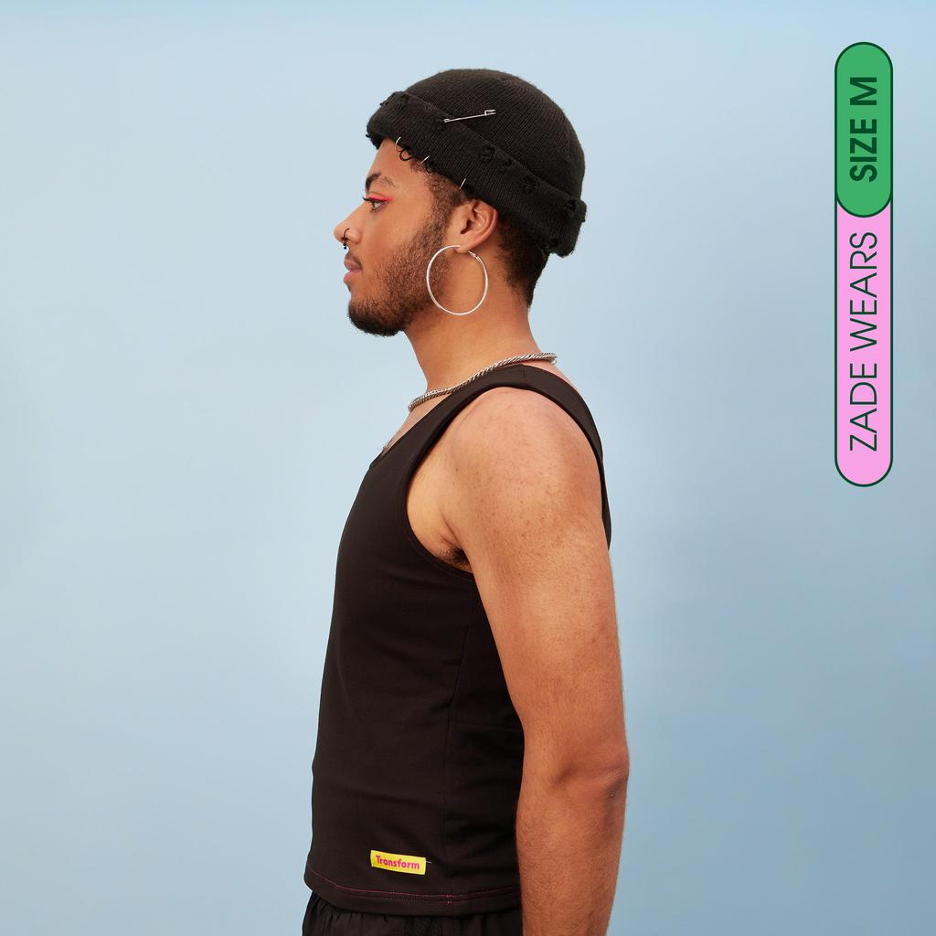 Zade wearing black, breathable tank chest binder - side view showing flattening effect